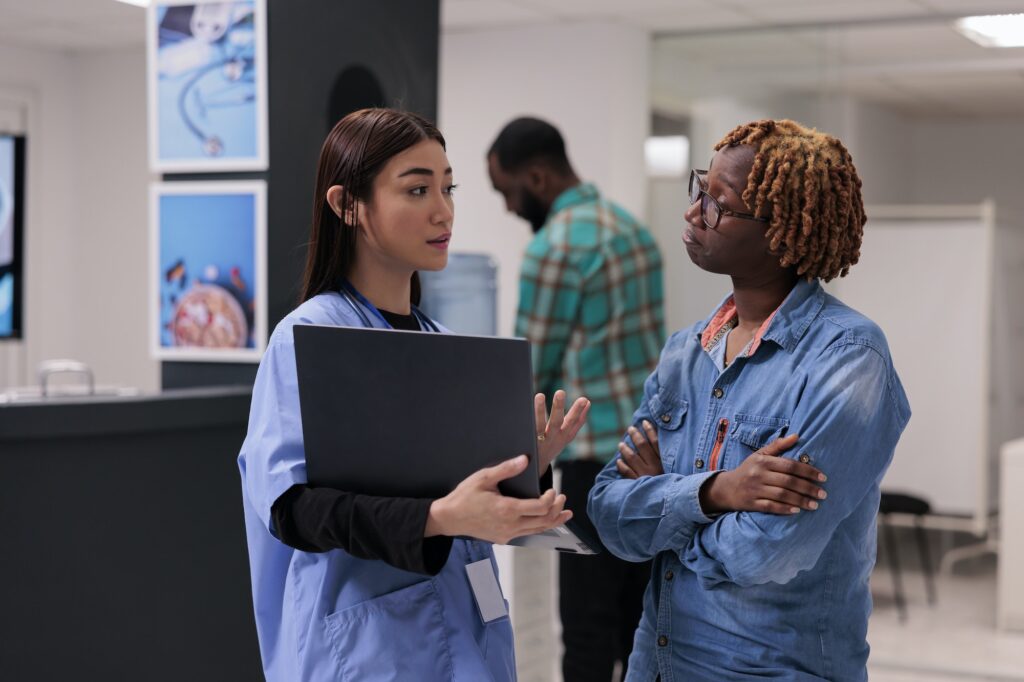 African american woman and nurse looking at laptop