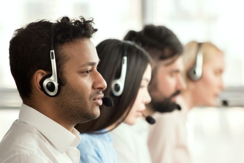 Black call center operator with colleagues.